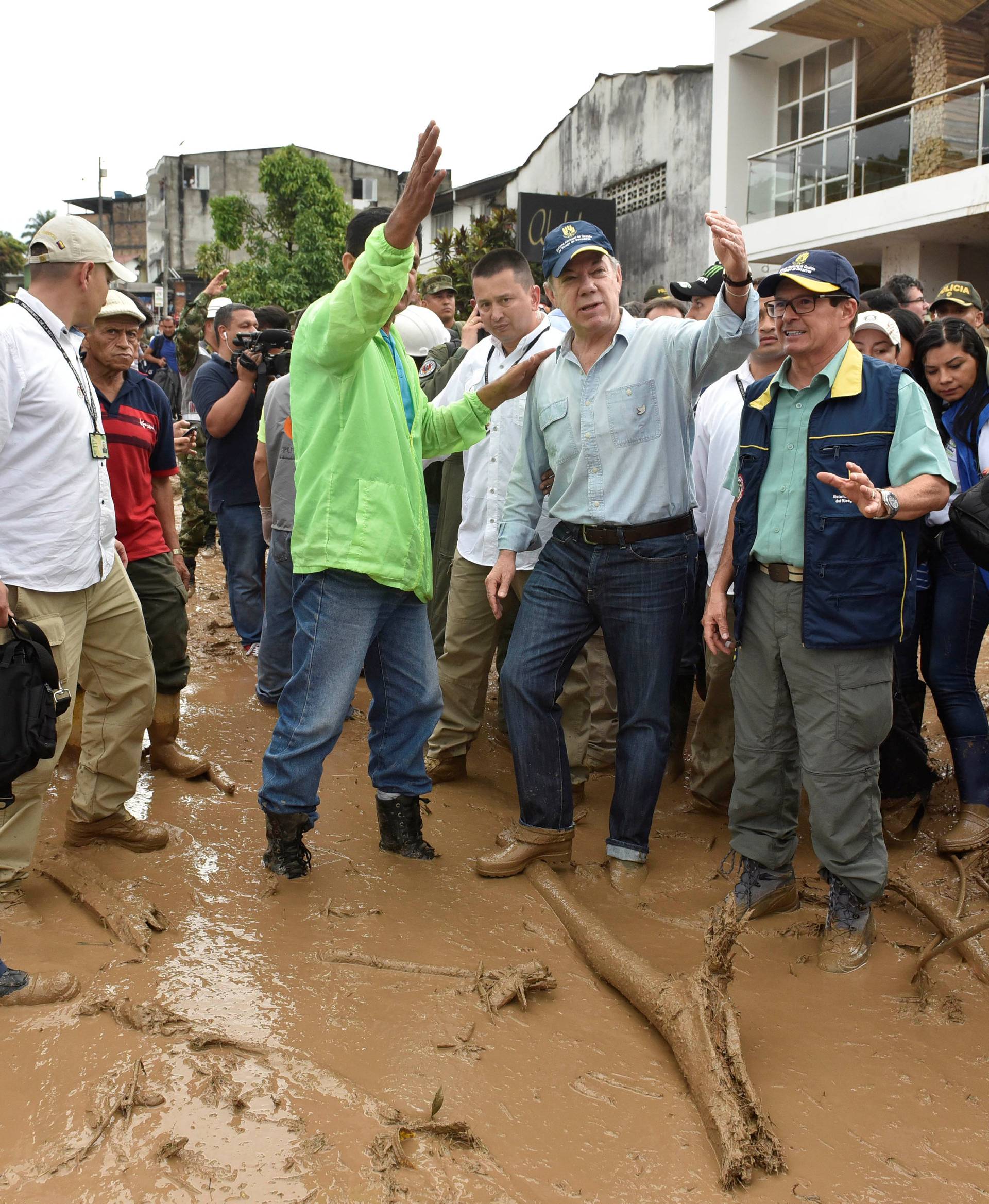 Colombia's President Juan Manuel Santos gestures while visiting a flooded area after heavy rains caused several rivers to overflow, pushing sediment and rocks into buildings and roads in Mocoa