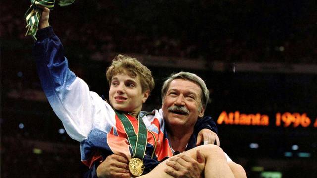 FILE PHOTO: Unofficial USA Women Gymnastics Coach Lifts Kerry Strug In The Air After Olympic Win