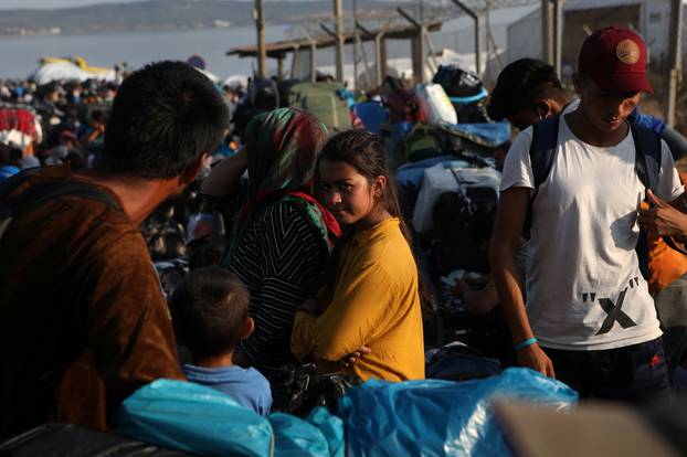 Refugees and migrants, from the destroyed Moria camp, line up to enter a new temporary camp, on the island of Lesbos