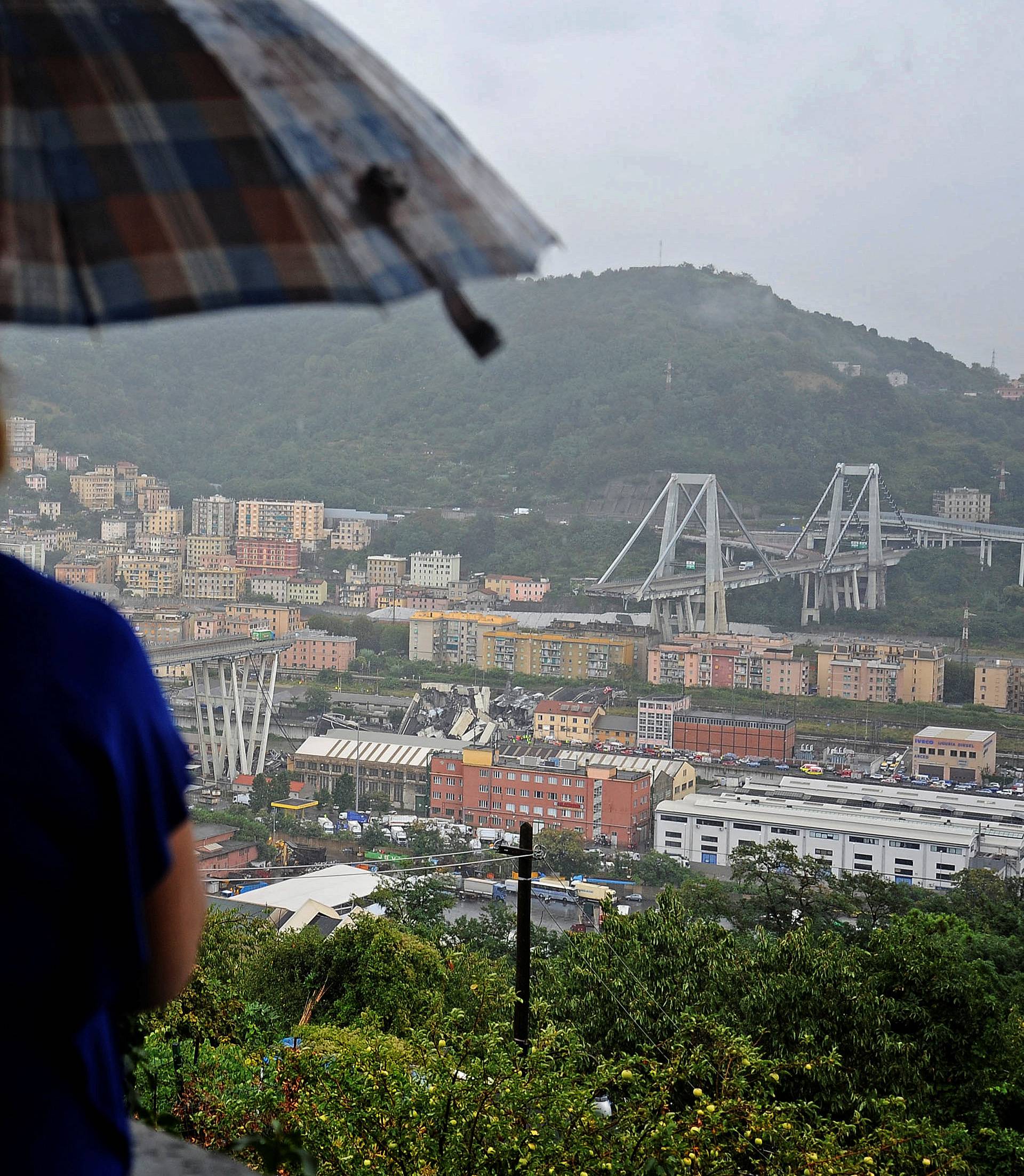 A couple look at the collapsed Morandi Bridge in the Italian port city of Genoa