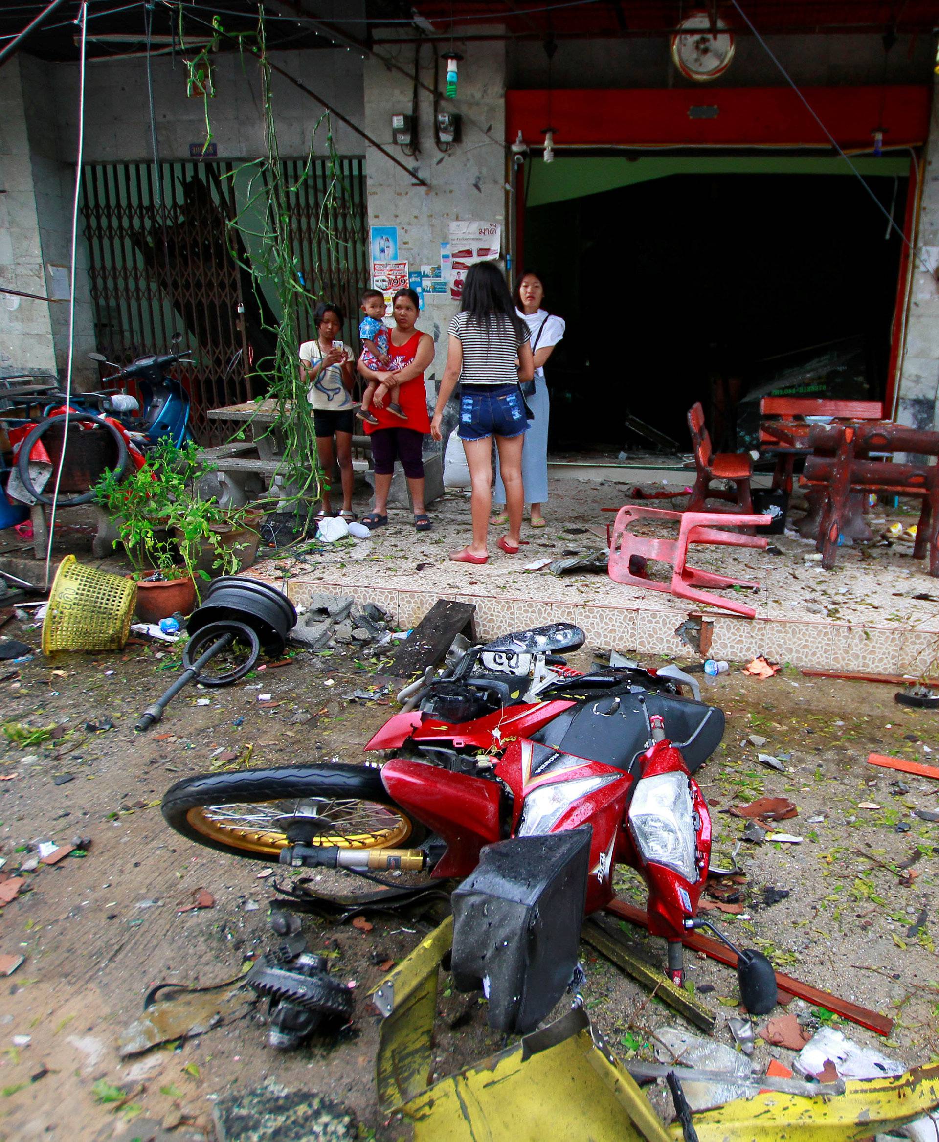 People stand at the scene after a blast outside a hotel in the southern province of Pattani