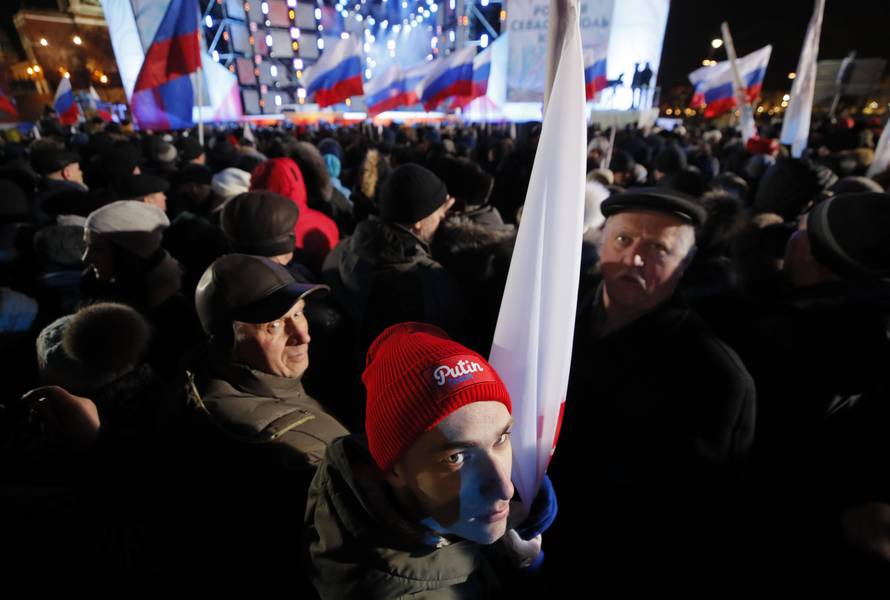 People attend a rally and concert marking the fourth anniversary of Russia's annexation of the Crimea region, at Manezhnaya Square in central Moscow