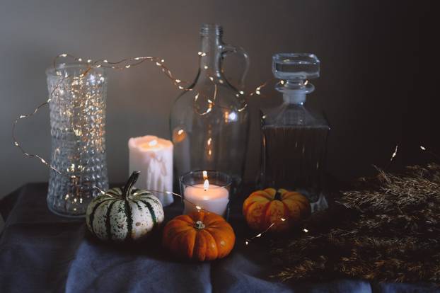 Cozy autumn home decor with candles and pumpking.