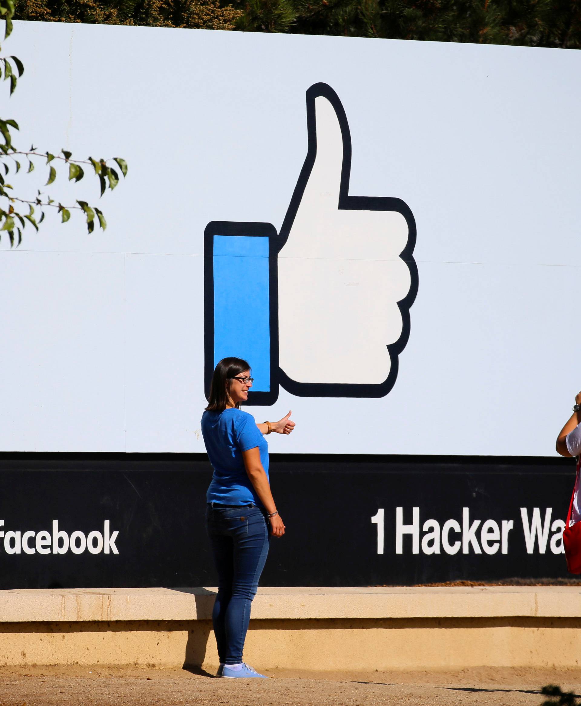 FILE PHOTO: Two women take photos in front of the entrance sign to Facebook headquarters in Menlo Park