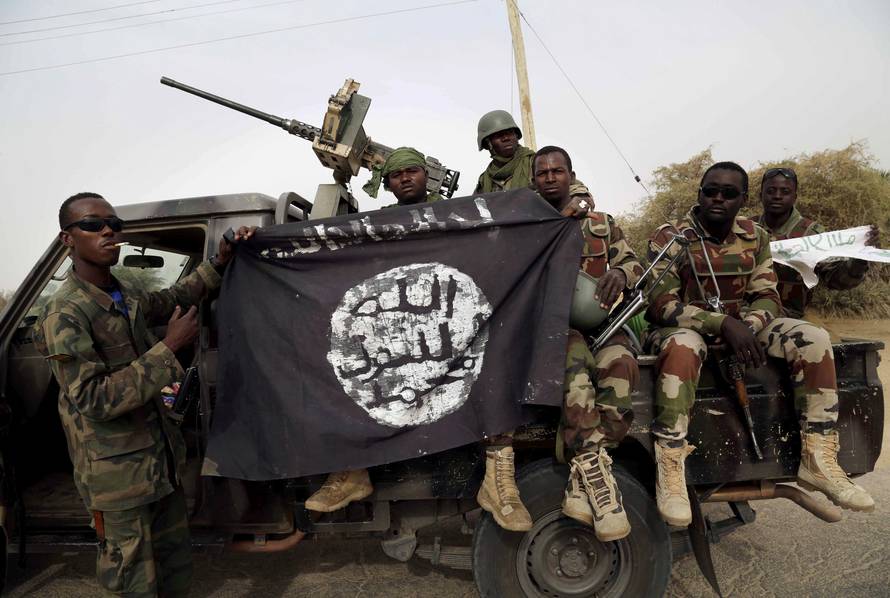 FILE PHOTO: Nigerian soldiers hold up a Boko Haram flag that they had seized in the recently retaken town of Damasak, Nigeria