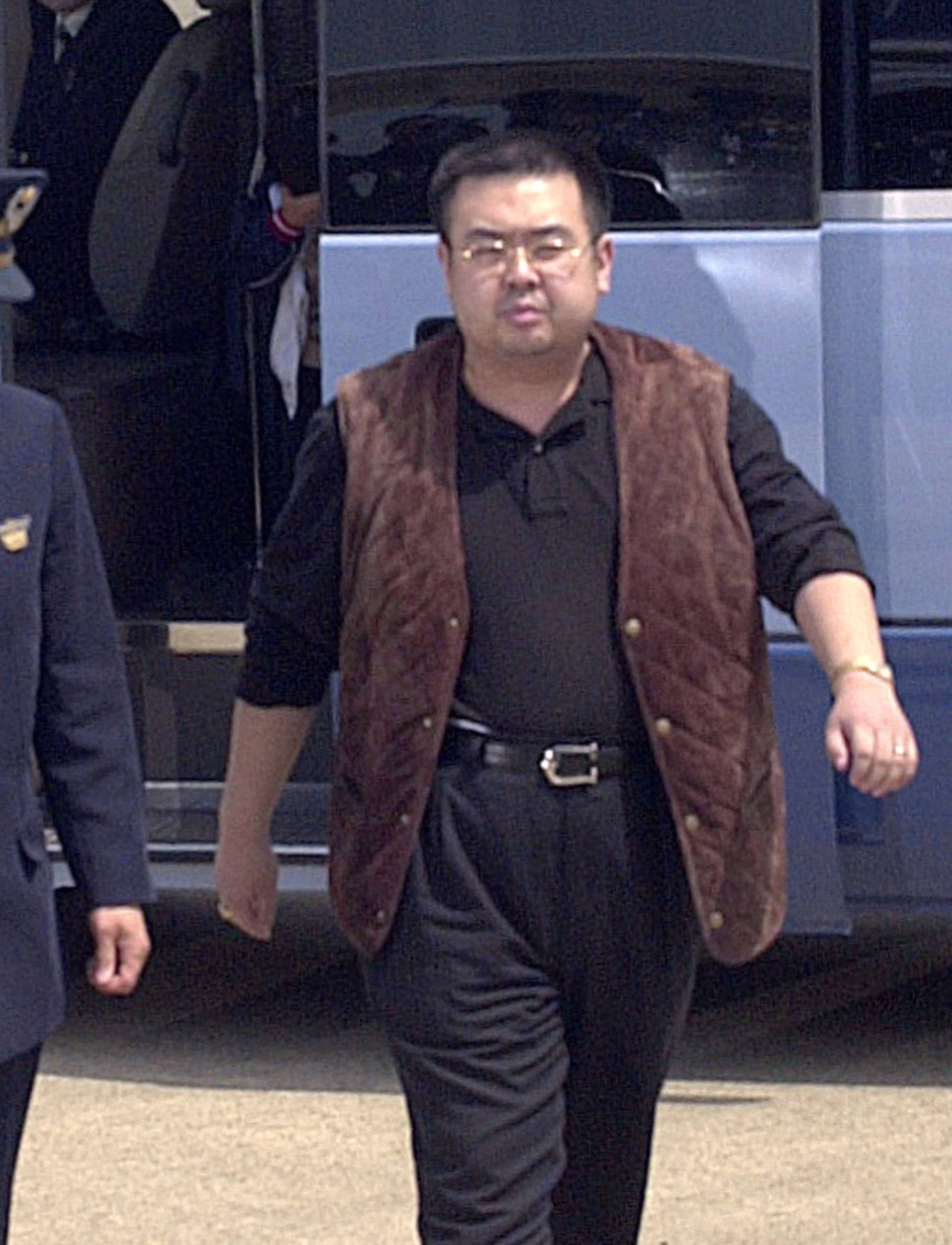 A man believed to be North Korean heir-apparent Kim Jong Nam is escorted by police as he boards a plane upon his deportation from Japan at Tokyo's Narita international airport in Narita, Japan