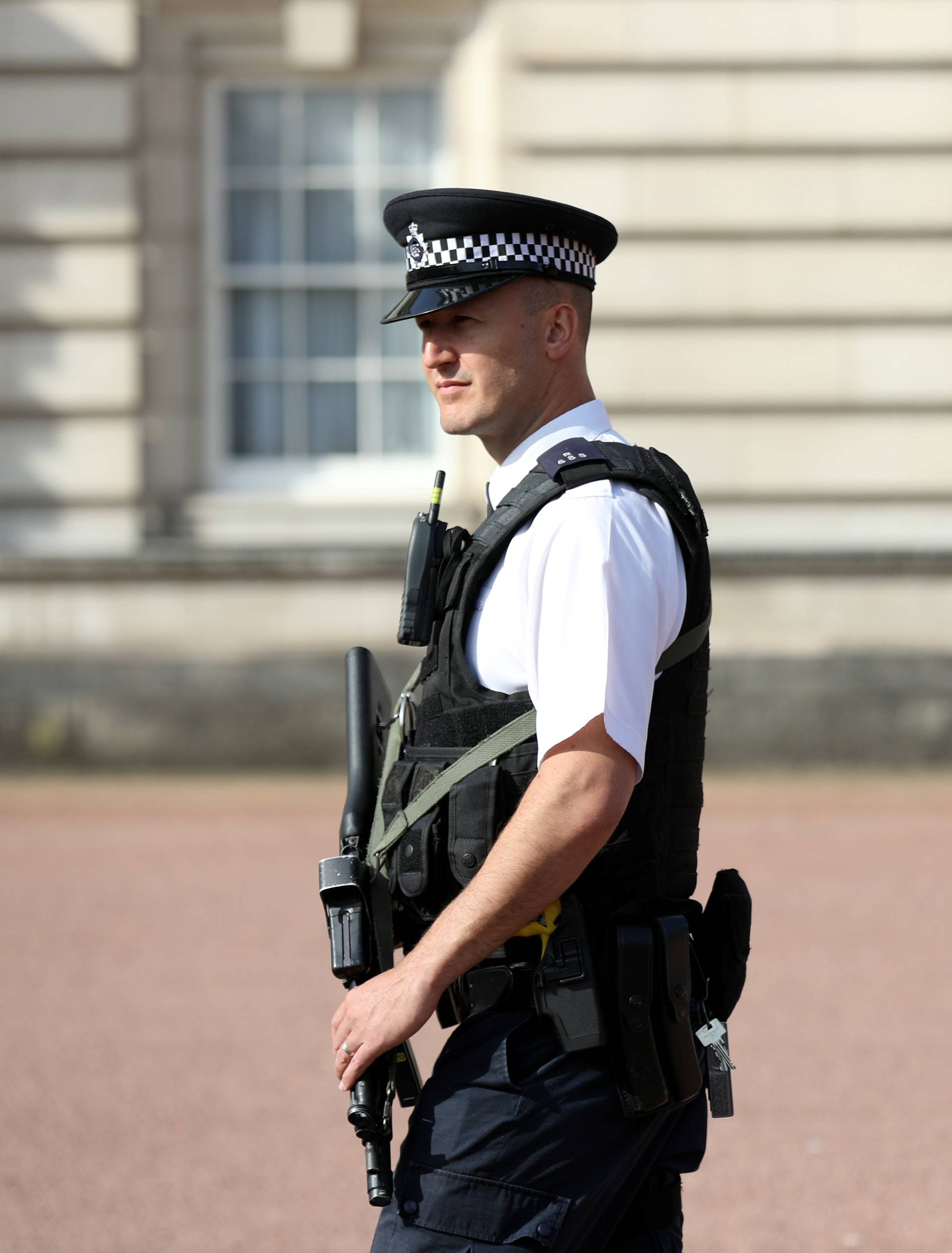 A police officer patrols within the grounds of Buckingham Palace in London