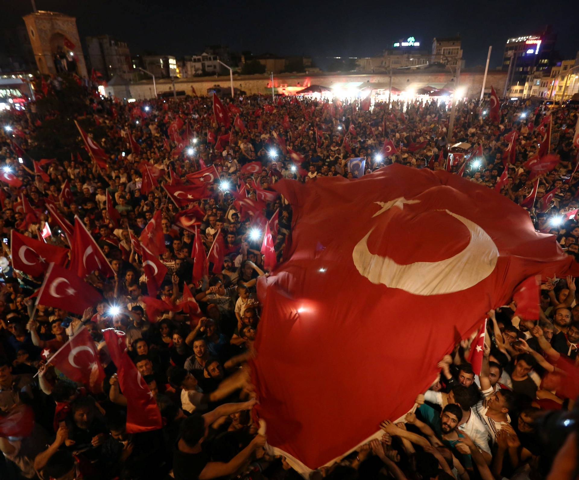 Supporters of Turkish President Erdogan wave national flags as they gather at Taksim Square in central Istanbul