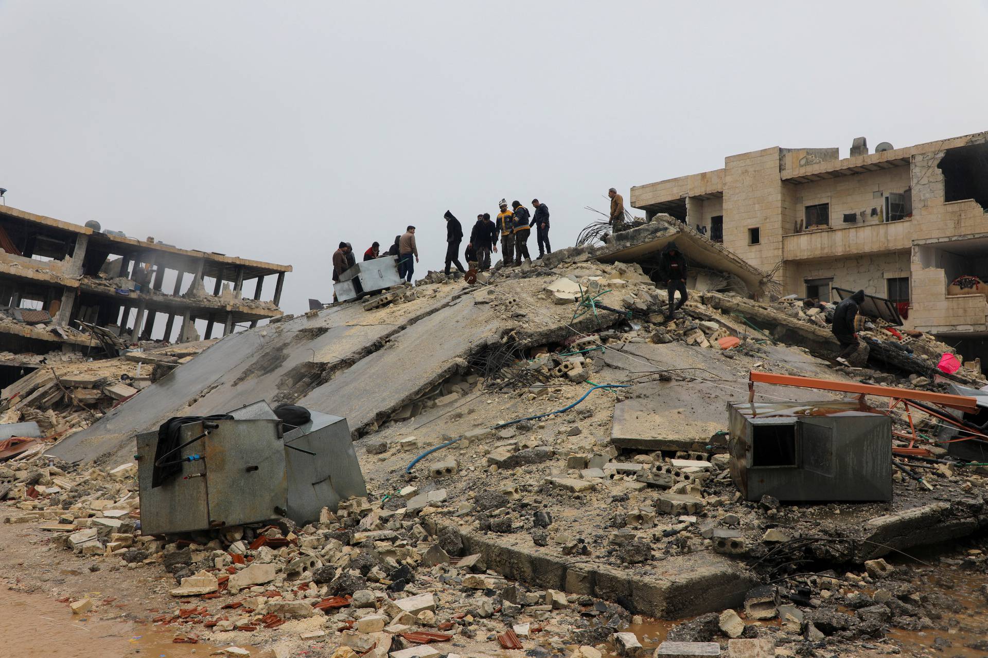 Rescuers search for survivors under the rubble, following an earthquake, in rebel-held town of Jandaris