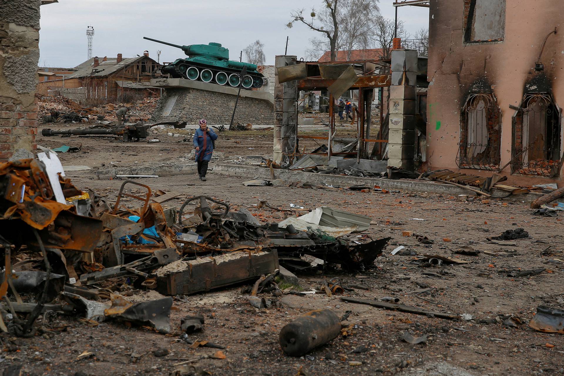 A local resident walks next to buildings damaged by shelling in Trostianets