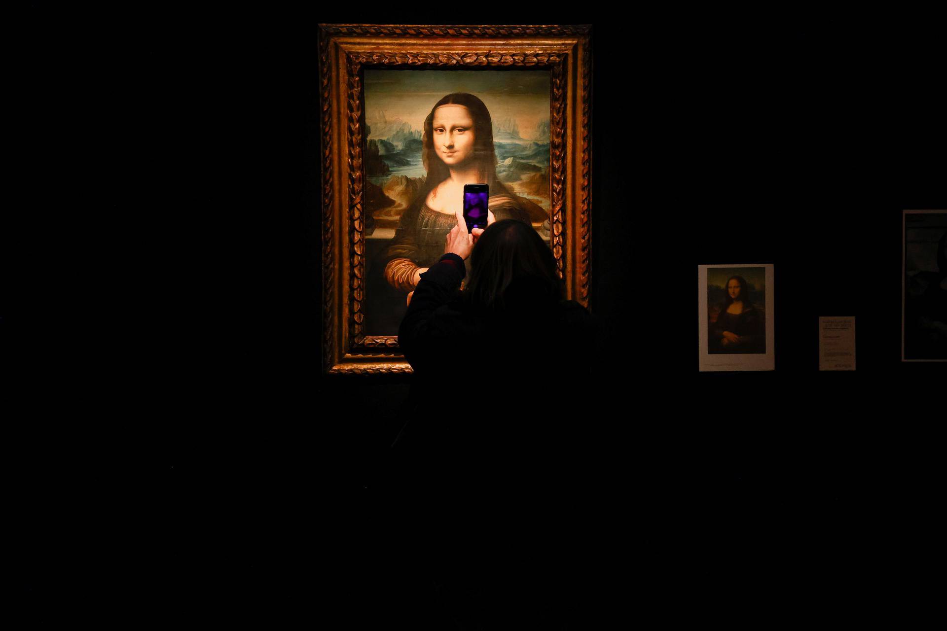 A visitor takes a photo of a copy of the Leonardo da Vinci's Mona Lisa, which will go up for auction on November 9, at the Artcurial auction house in Paris