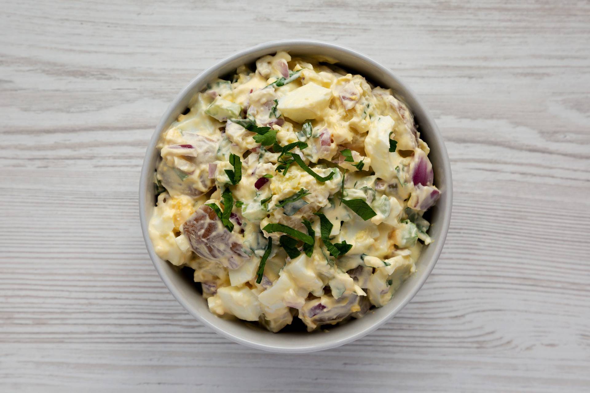 Homemade Healthy Potato Salad with Eggs in a Bowl, top view. Fla