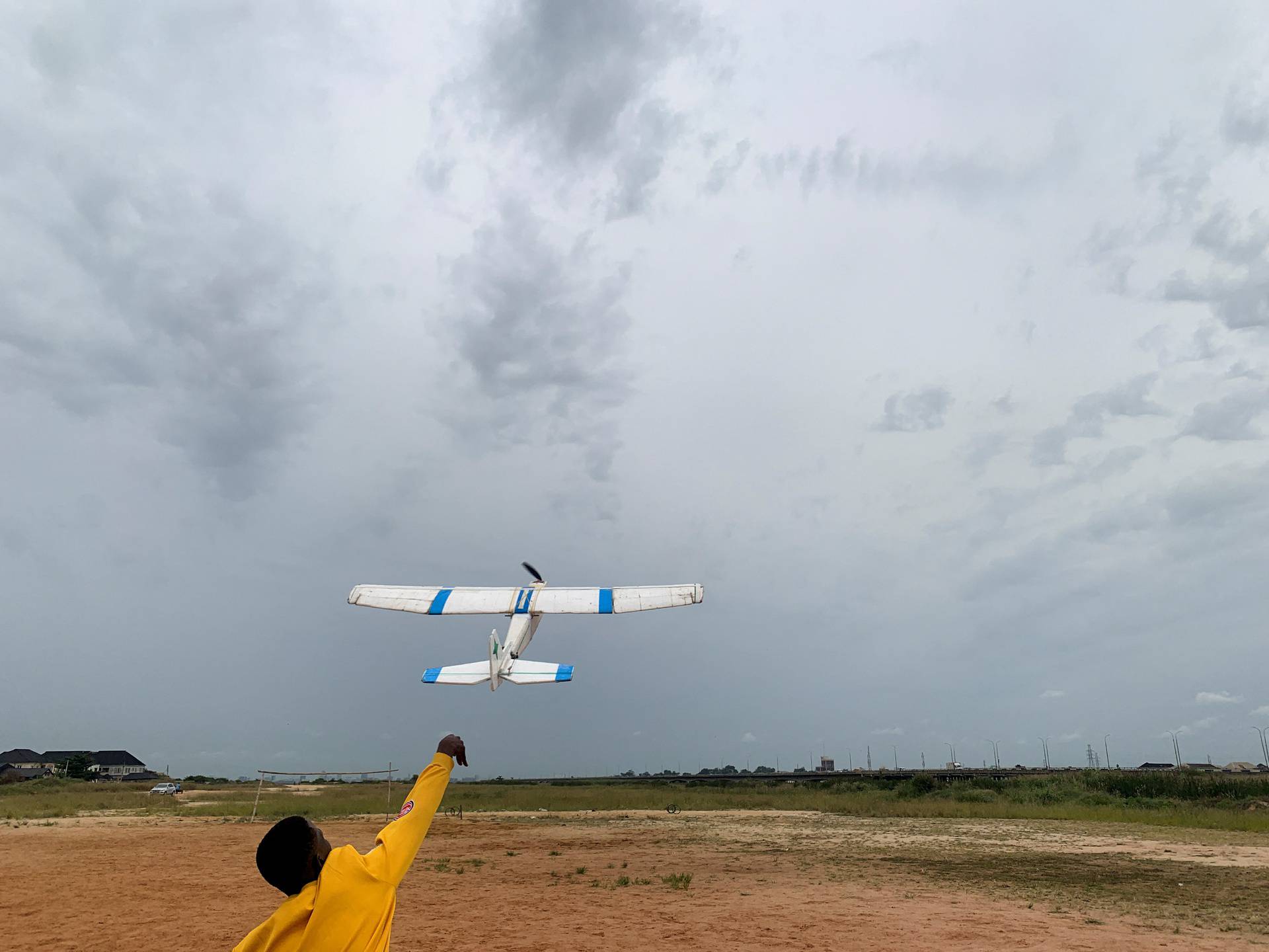 Damilare Ajayi, a friend of Bolaji Fatai, who built the model aeroplane from discarded waste, launches the aeroplane into the sky, in Lagos