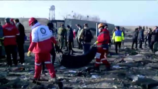 Emergency workers work near the wreckage of Ukraine International Airlines flight PS752, a Boeing 737-800 plane that crashed after taking off from Tehran