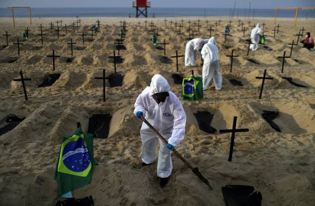 Activists of the NGO Rio de Paz in protective gear dig graves on Copacabana beach to symbolise the dead from the coronavirus disease (COVID-19) during a demonstration in Rio de Janeiro