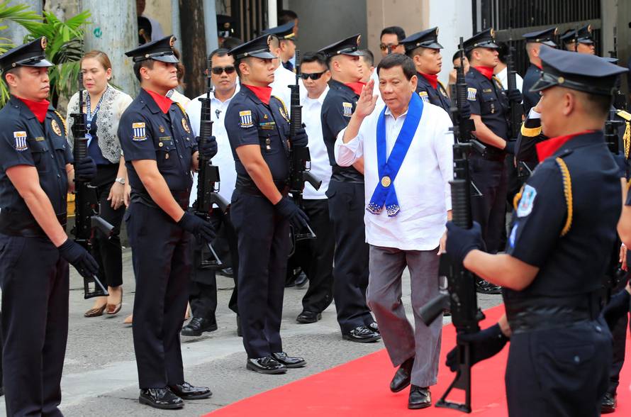 President Rodrigo Duterte salutes while passing members of custom police, upon arrival to witness the destruction of condemned smuggled luxury cars worth 61,626,000.00 pesos (approximately US$1.2 million), in Metro Manila