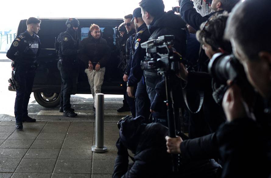 Mohamed Amra is escorted to the tarmac by police officers at Bucharest Henri Coanda International Airport