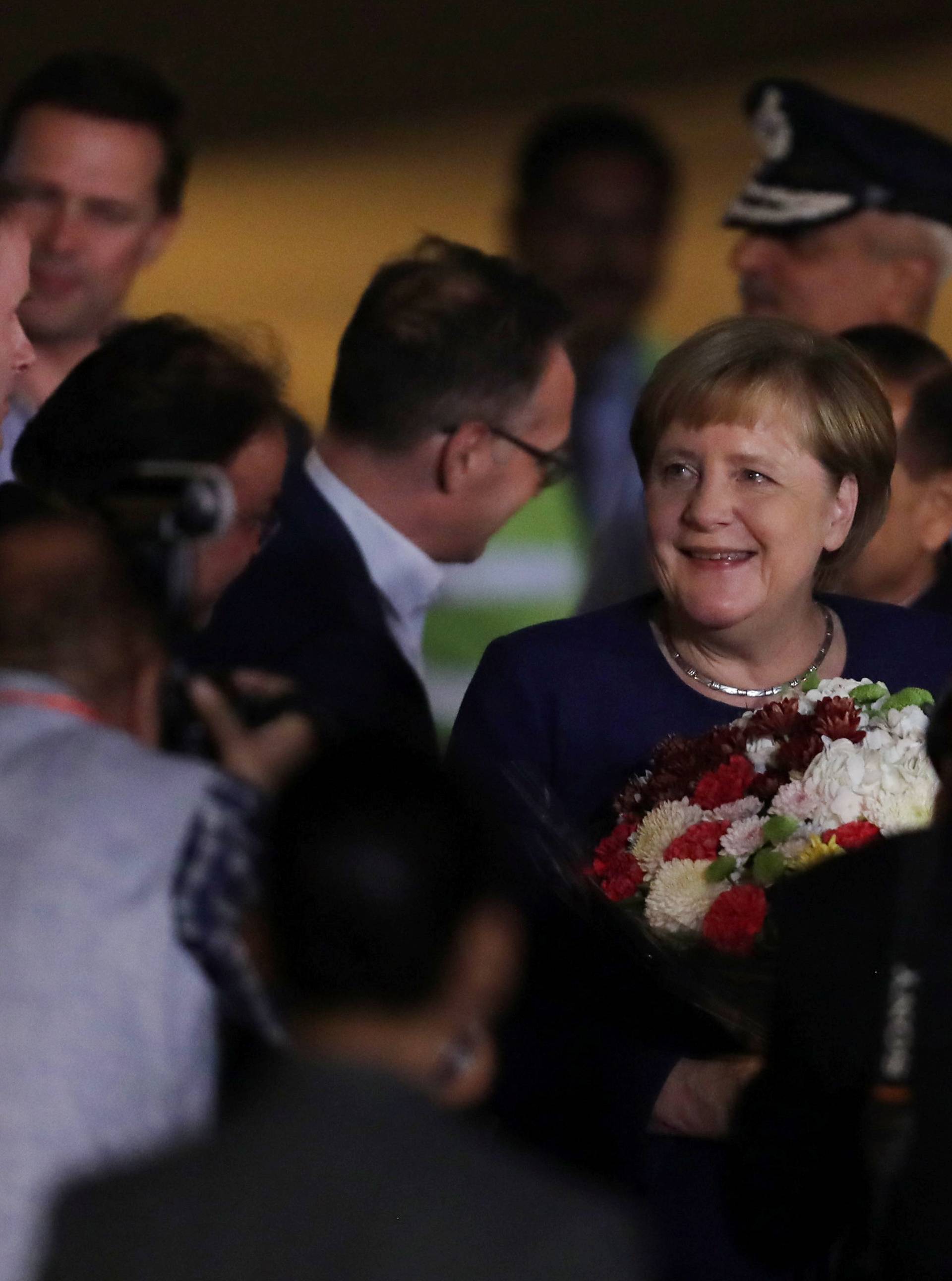 German Chancellor Angela Merkel is welcomed upon her arrival at an airport in New Delhi