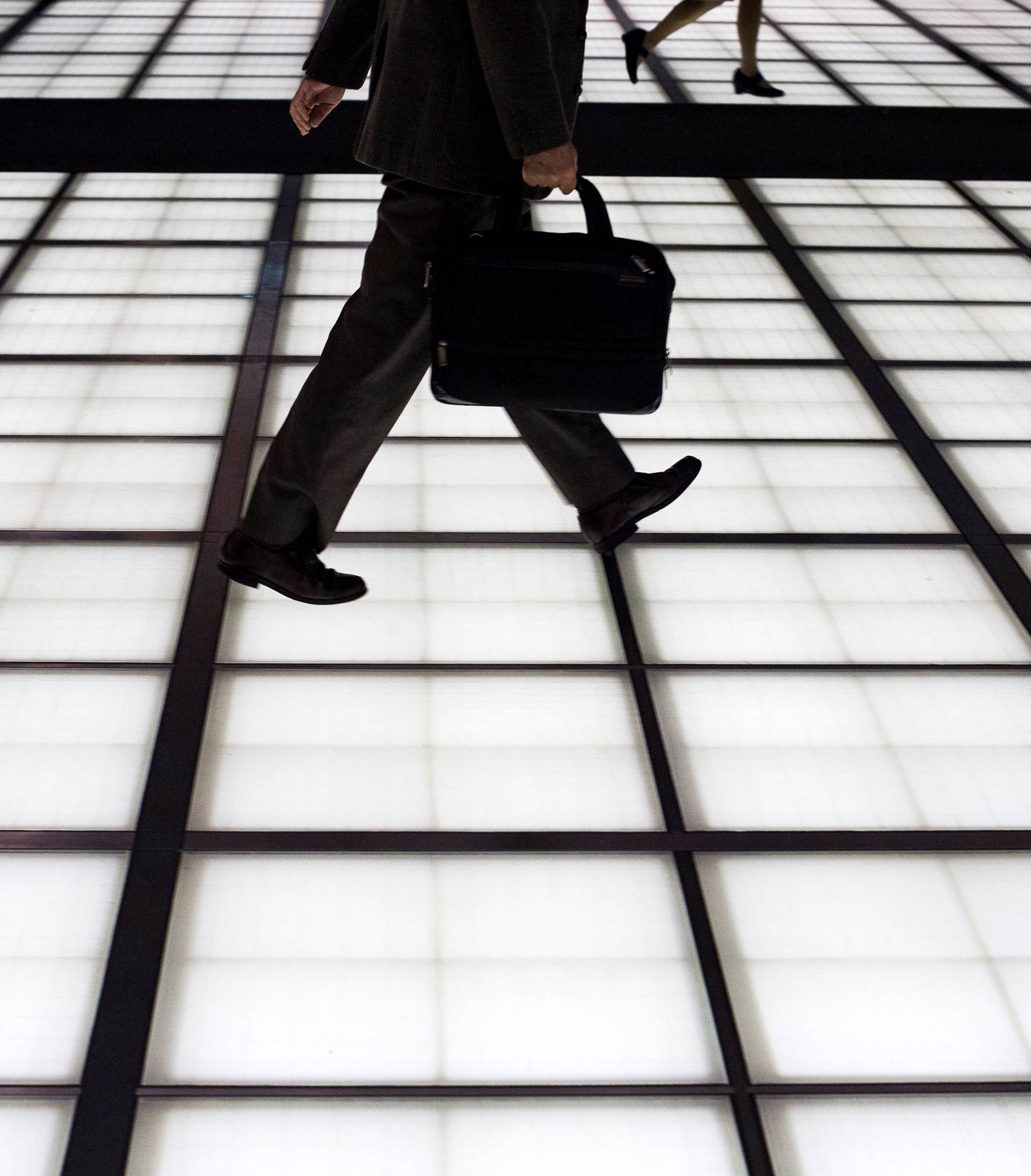 People cross an illuminated floor at a banking district in central Tokyo