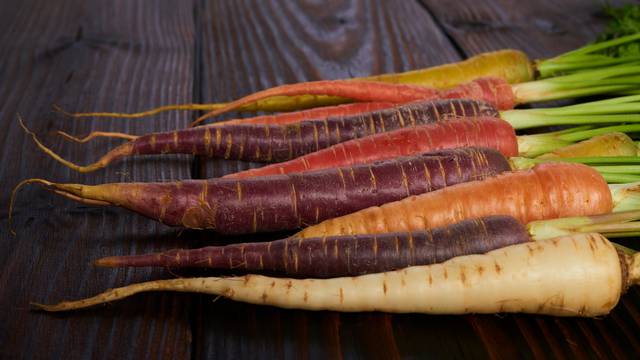 Color carrot with leaves at organic greengrocer's shop. stock photo.