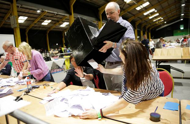 Electoral workers empty a ballot box at the count centre as votes are tallied folowing yesterday