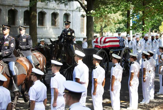 The horse drawn caisson bearing the body of Sen. McCain moves through the grounds of the United Sates Naval Academy in Annapolis