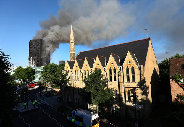 Police officers cordon off an area close to the scene of a serious fire in a tower block at Latimer Road in West London