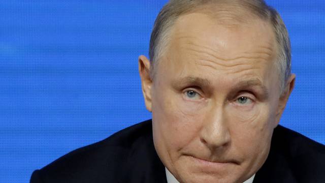 Russian President Putin listens during annual news conference in Moscow