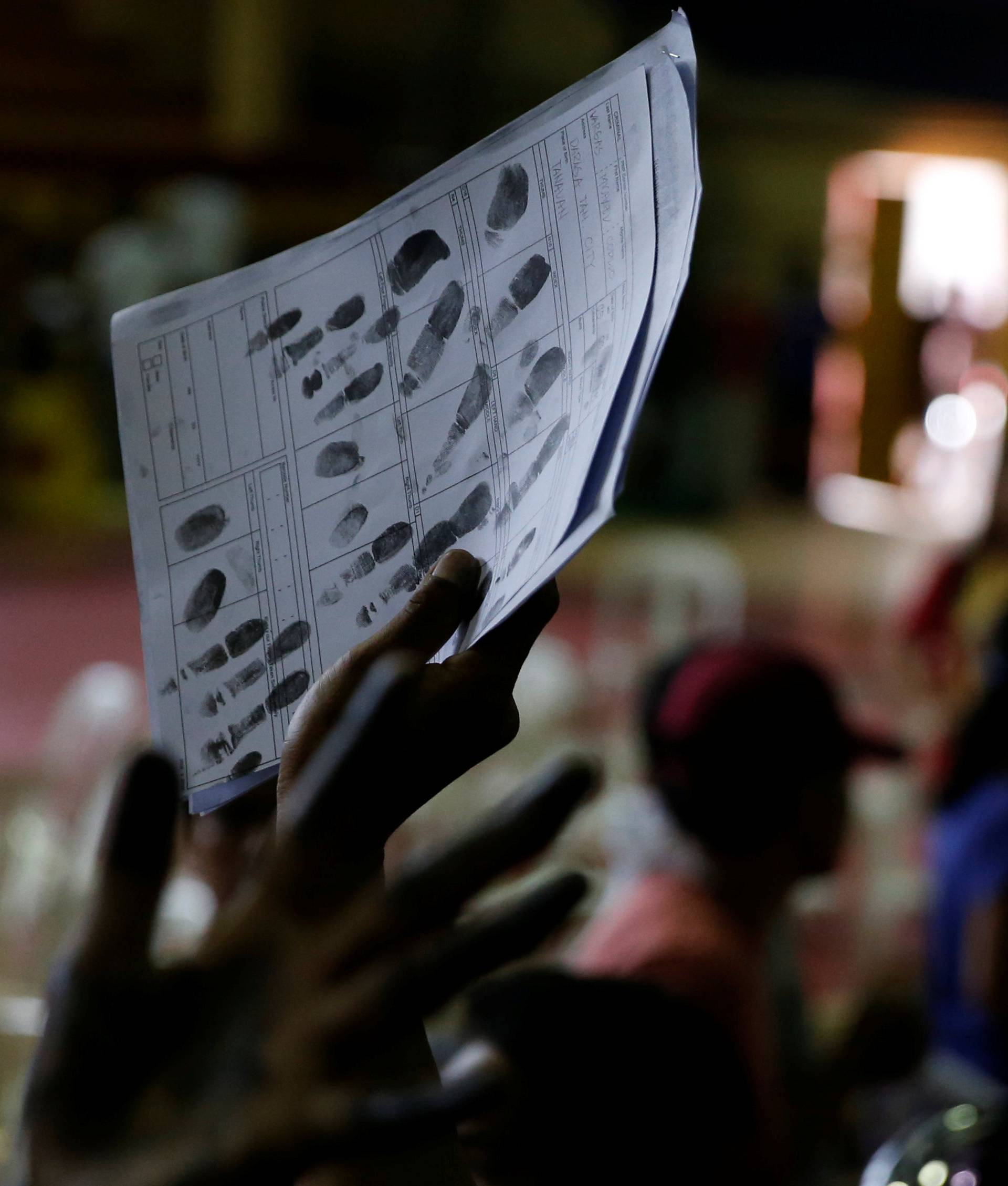 A drug user holds up a copy of his fingerprints, after more than 1000 residents surrendered to local officials as they follow a government campaign against drugs in Tanauan Batangas, south of Manila