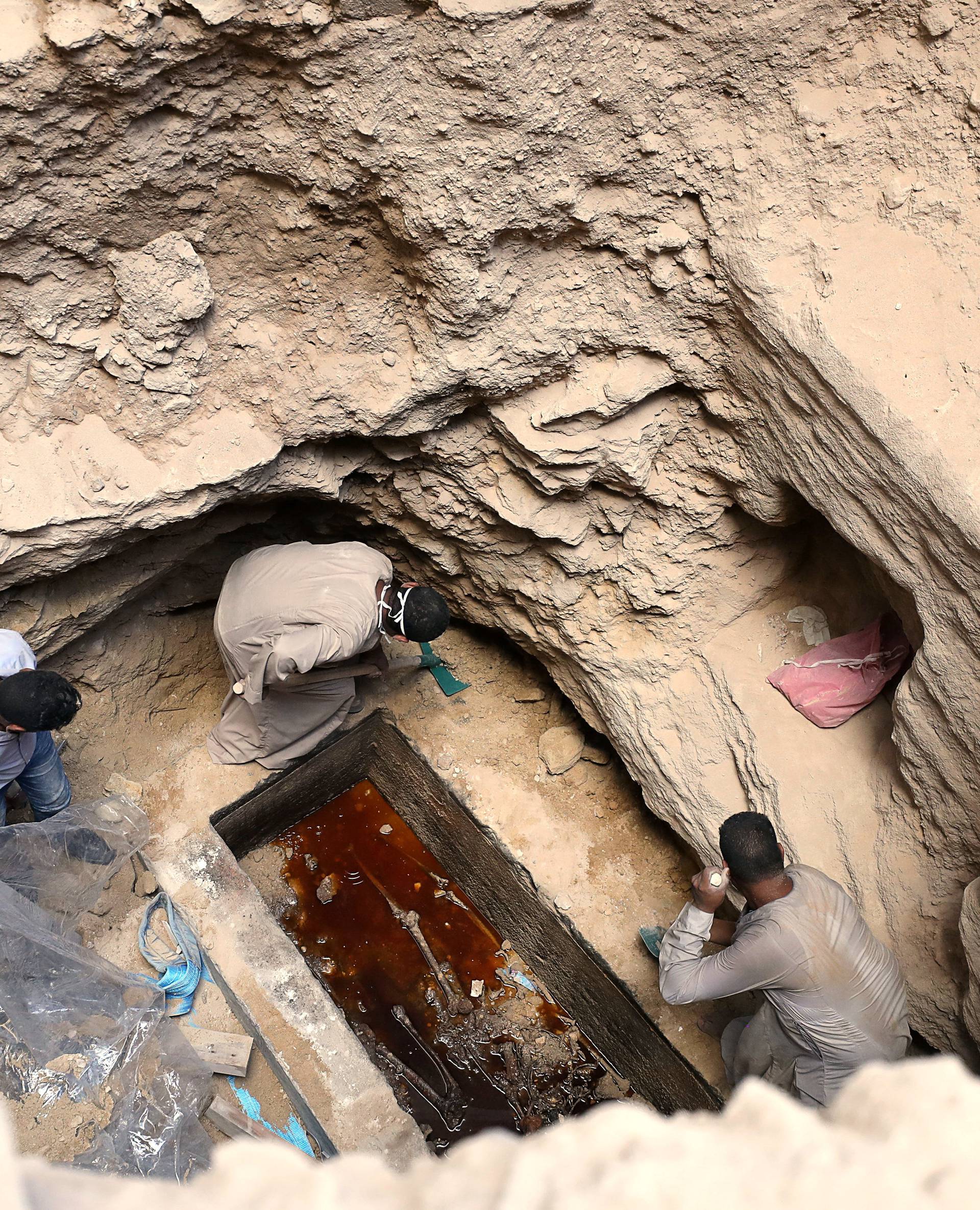 Archaeologists unearth coffin containing three mummies with sewage water and bones inside, in Alexandria