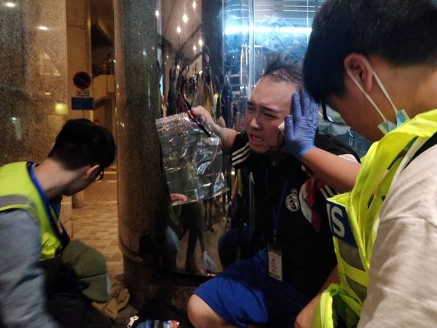 Andrew Chiu Ka Yin, District Councillor of Taikoo Shing West, receives help from first aid volunteers after sustaining an injury in a knife attack at a shopping mall, in Taikoo Shing in Hong Kong
