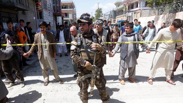 An Afghan security forces mamber stands guard at the site of a suicide bomb attack in Kabul