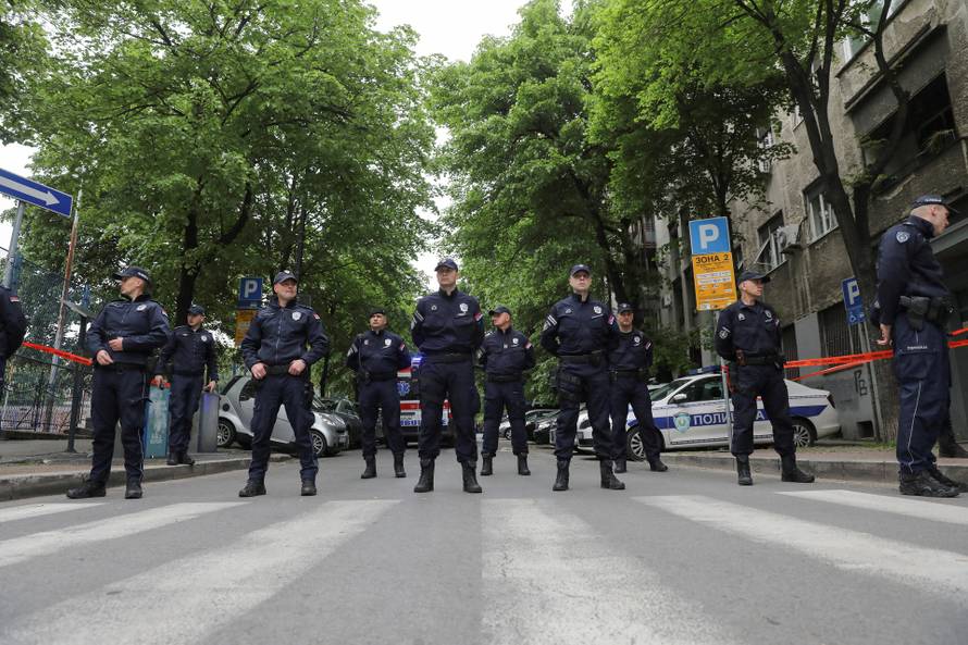 Police officers secure the area after a 14-year-old boy opened fire on other students and security guards at a school in downtown Belgrade