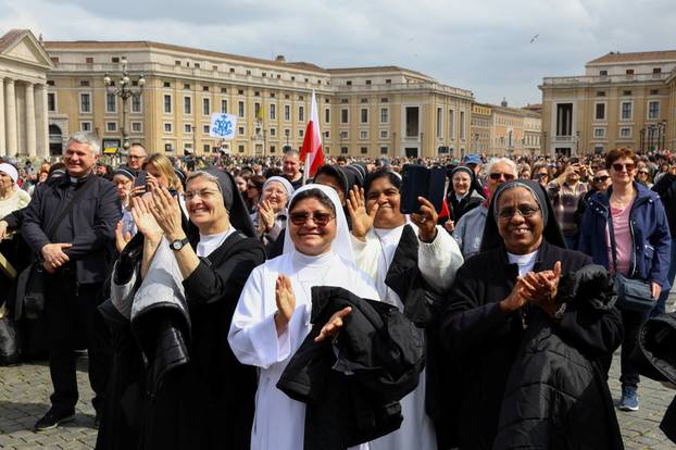 People watch Pope Francis makes first public appearance in five weeks, on a big screen in St. Peter's Square at the Vatican