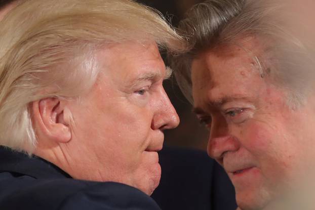 FILE PHOTO: U.S. President Donald Trump talks to chief strategist Steve Bannon during a swearing in ceremony for senior staff at the White House in Washington