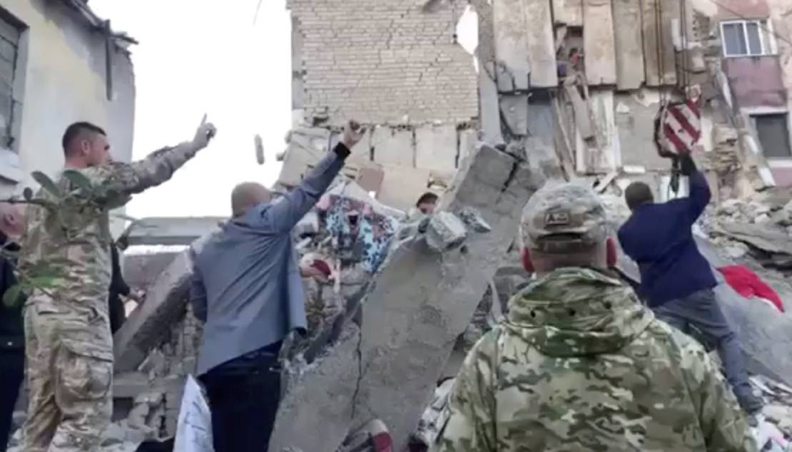 Military personnel and locals remove debris from damaged buildings after an earthquake in Thumane, Albania