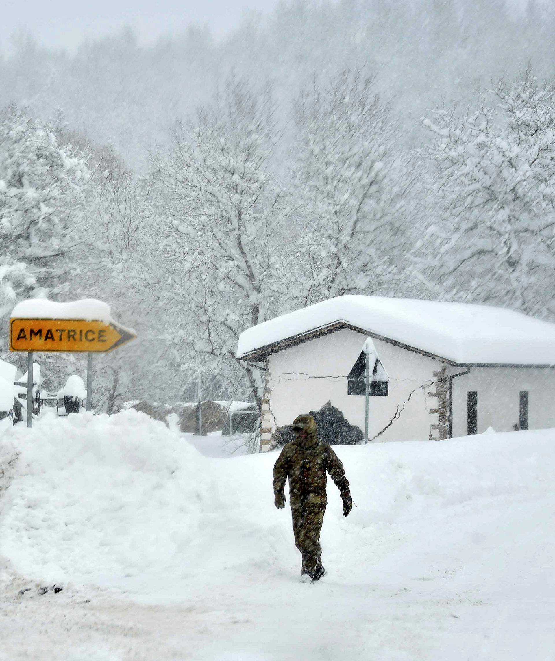 A soldier walks during a heavy snowfall in Amatrice, after a series of earthquakes hit the town and parts of central Italy