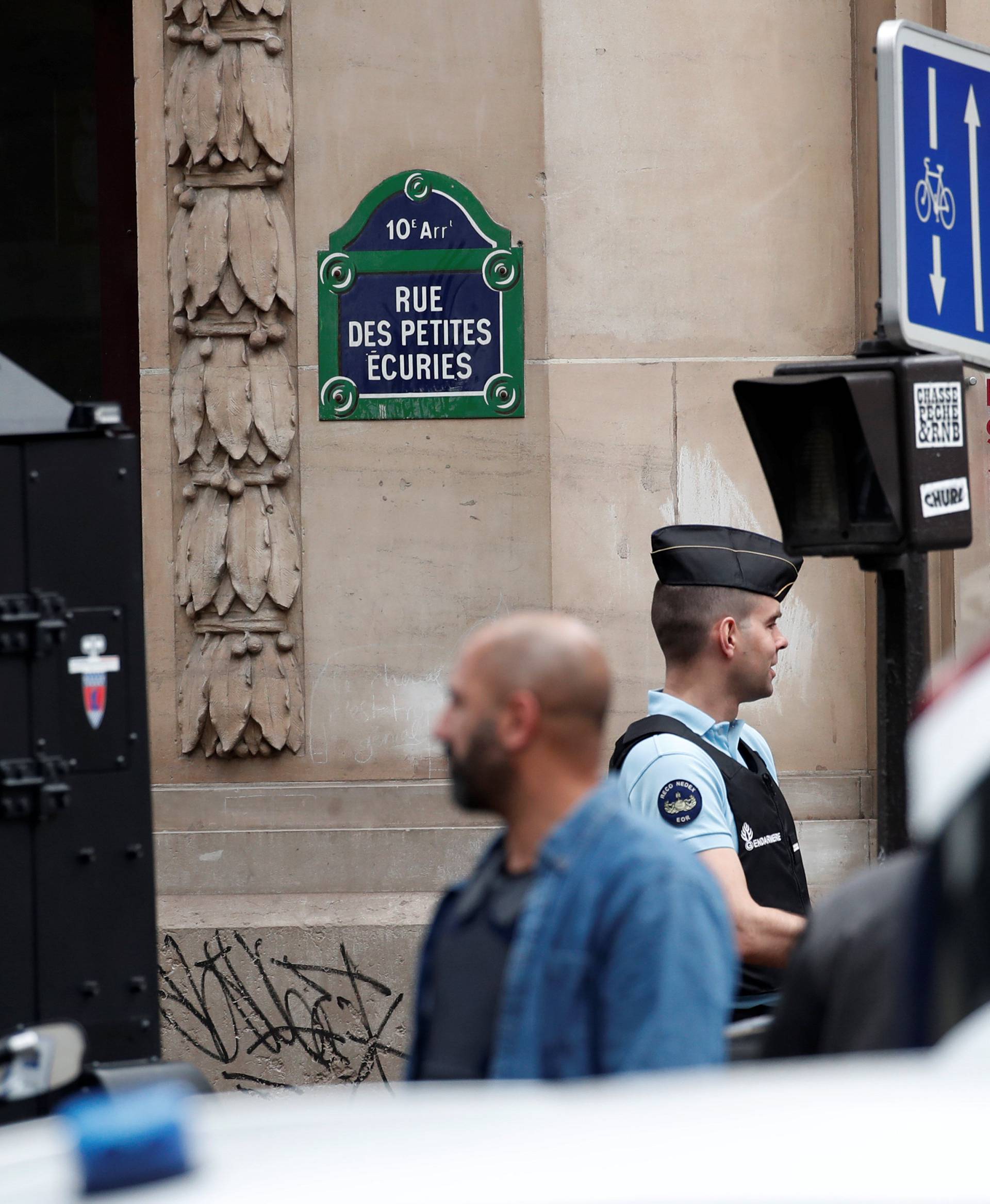 French police and special police forces (BRI) secure the street as a man has taken people hostage at a business in Paris