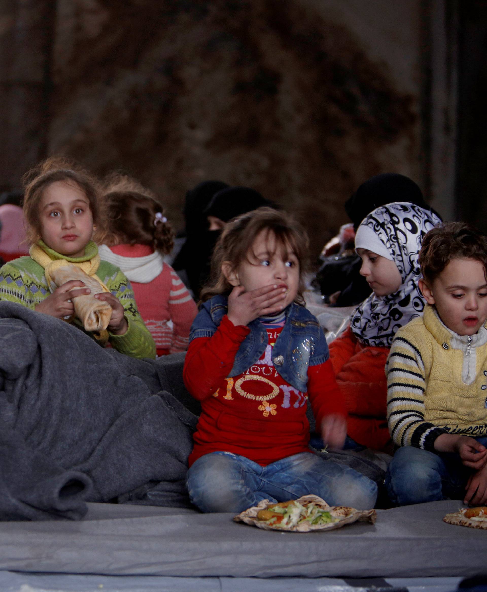 Syrians that evacuated eastern Aleppo, have a meal in a shelter in government-controlled Jibreen area in Aleppo