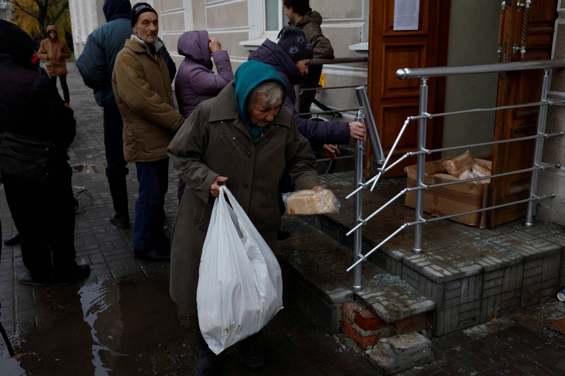 People come out of their underground shelters to receive aid, in Bakhmut