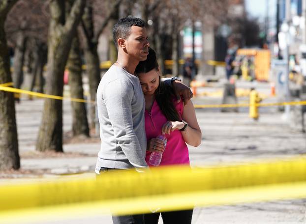 People react to an incident where a van struck multiple people at a major intersection in Toronto