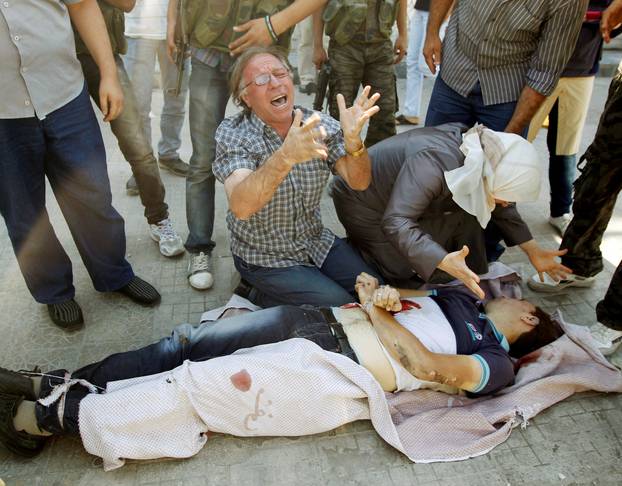 FILE PHOTO: A man and woman cry over the body of their son in Aleppo