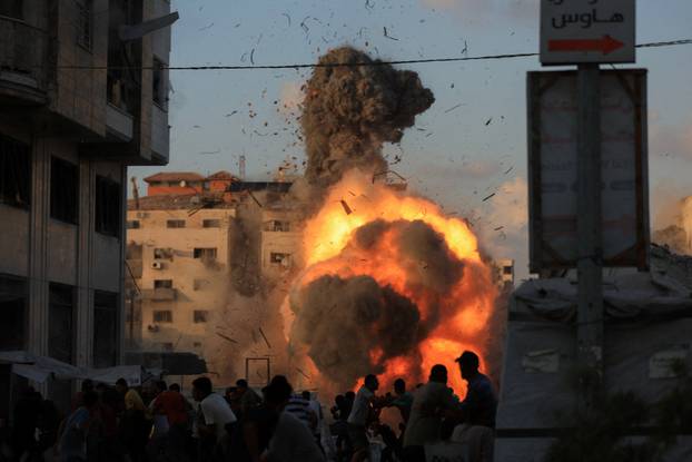 Smoke and flames rise as a residential building collapses after an Israeli air strike, in Gaza City