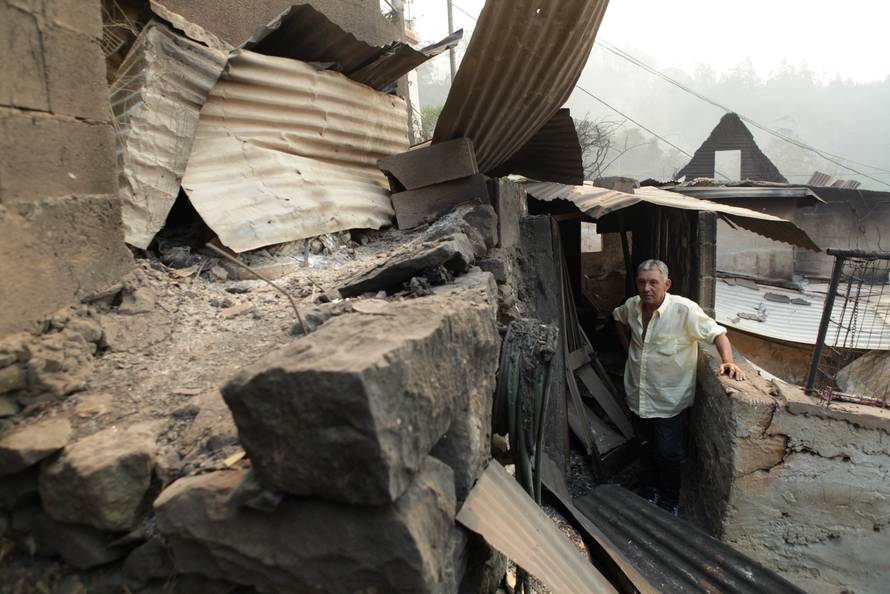 Avelino Viveiros poses for a photo after his house was burnt yesterday at Curral dos Romeiros