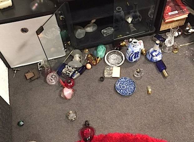 Belongings that were dislodged from a cabinet due to an earthquake lay across the floor in a home in Wellington, New Zealand