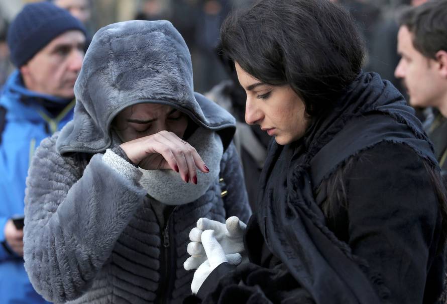 Women who survived an attack by a gunman, react outisde the Reina nightclub by the Bosphorus, in Istanbul