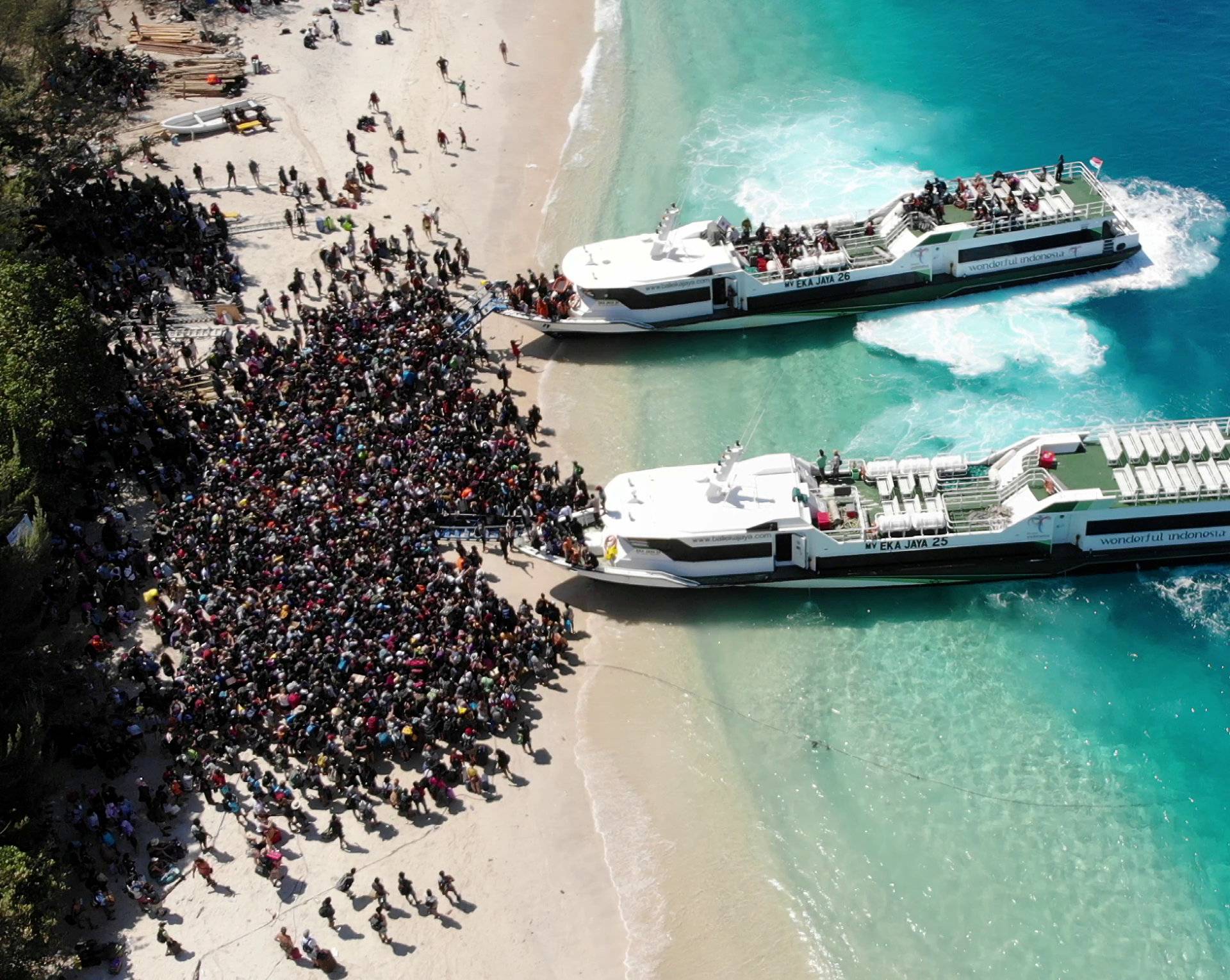 Boats arrive at shore to evacuate people on the island of Gili Trawangan, Lombok