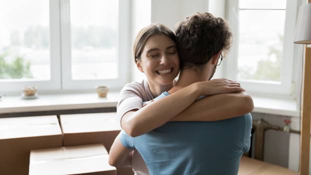 Happy young married couple of apartment buyers celebrating relocation