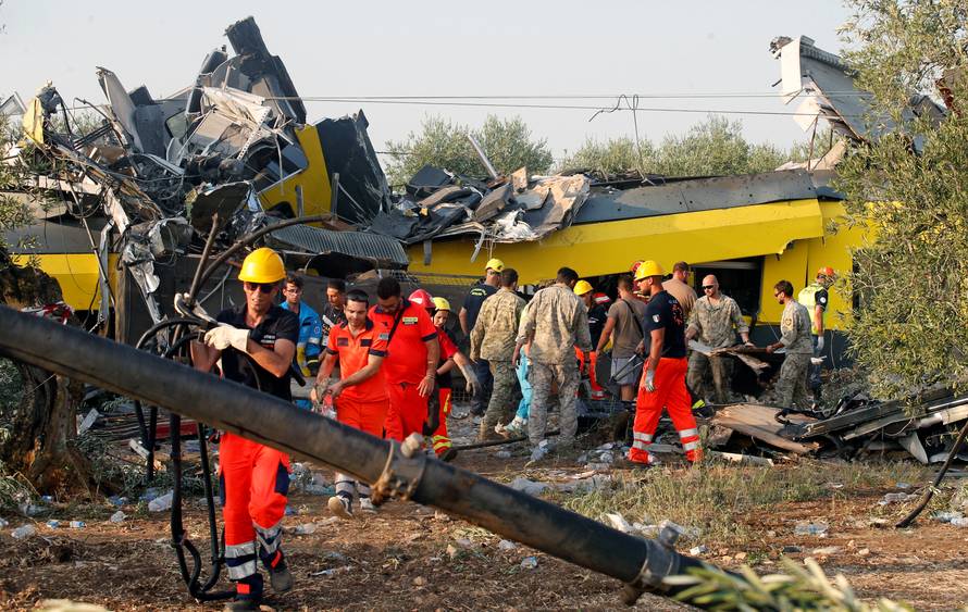 Rescuers work at the site where two passenger trains collided in the middle of an olive grove in the southern village of Corato