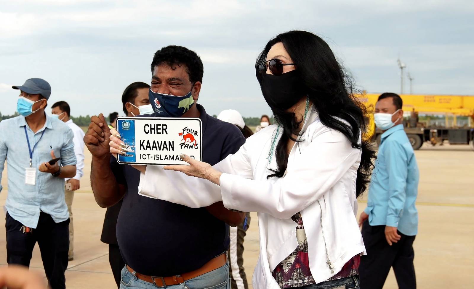 Singer Cher holds a plate with the name of elephant Kaavan at the Siem Reap Airport in Cambodia